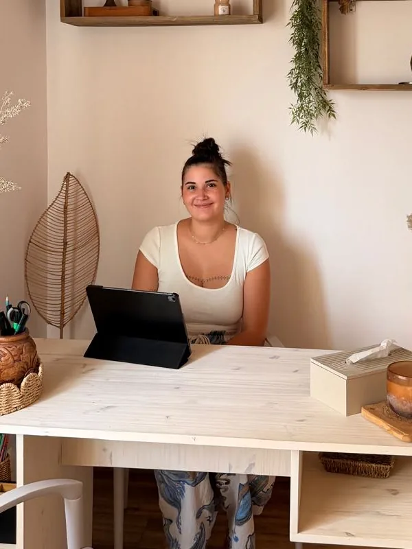 Delia, souriante, assise à son bureau au cabinet